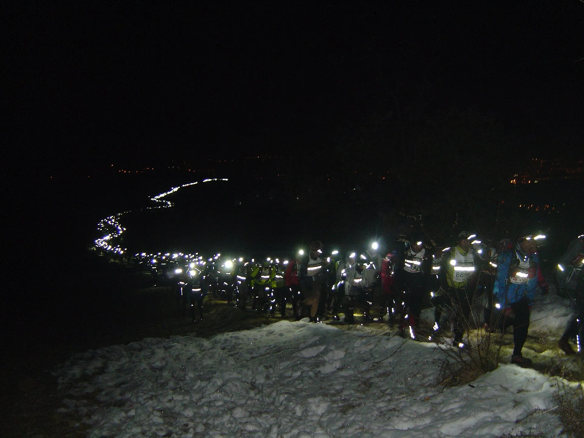 Coureurs munis de lampes frontales sur un sentier de trail nocturne